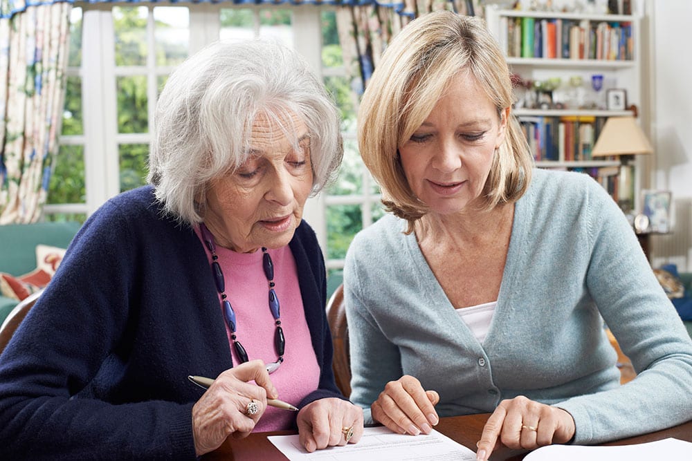 Adult Guardian helping a senior complete a form